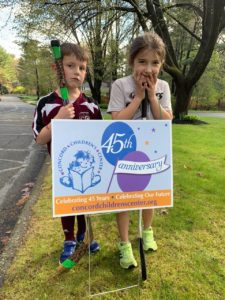 Two CCC alumni students with 45th anniversary sign