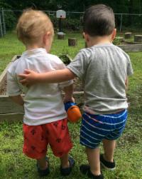 Two toddlers with their arms around each other